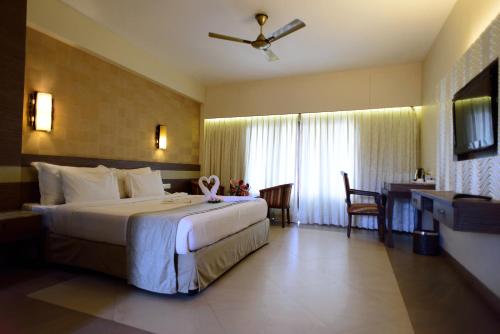 pokój hotelowy z dużym łóżkiem i biurkiem w obiekcie La Grace Resort w mieście Benaulim