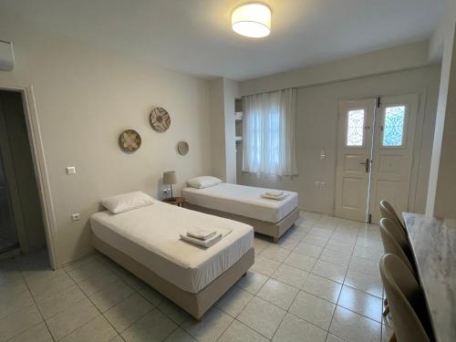 a bedroom with two beds and a window at Manto Apartments in Tinos Town