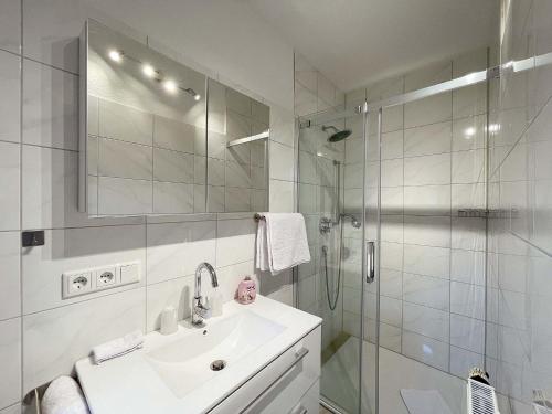 uma casa de banho branca com um lavatório e um chuveiro em Marions Apartments Greetsiel em Greetsiel