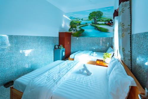 um quarto com uma cama branca e uma fotografia na parede em Khách Sạn Ngọc Hoa em Thăng Bình