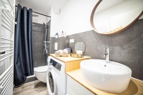 une salle de bain avec un lavabo et une machine à laver dans l'établissement La Parenthèse Parking Plage TOP PROS SERVICESConciergerie La Grande Motte, à La Grande Motte
