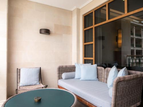 a patio with a couch and a table and chairs at Savoy Seychelles Resort & Spa in Beau Vallon