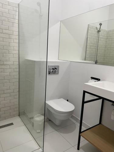 Baño blanco con aseo y lavamanos en Staycity Apartments Sukiennice 6, en Wroclaw