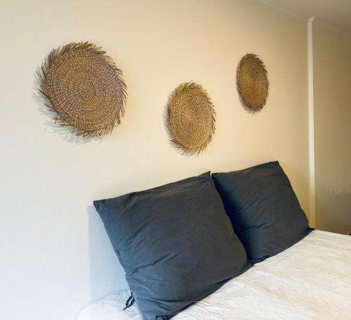 1 dormitorio con 1 cama con 3 sombreros de paja en la pared en Departamentos Duarte Quiros en Córdoba