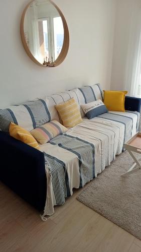 - un canapé bleu et blanc dans un salon avec un miroir dans l'établissement L'Appartement du Mourillon, à Toulon