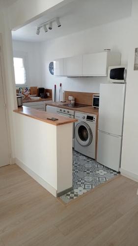 une cuisine avec un réfrigérateur et une machine à laver dans l'établissement L'Appartement du Mourillon, à Toulon