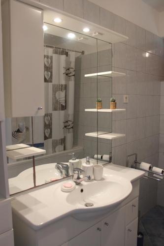 W łazience znajduje się biała umywalka i lustro. w obiekcie Villa Blue w mieście Zaton