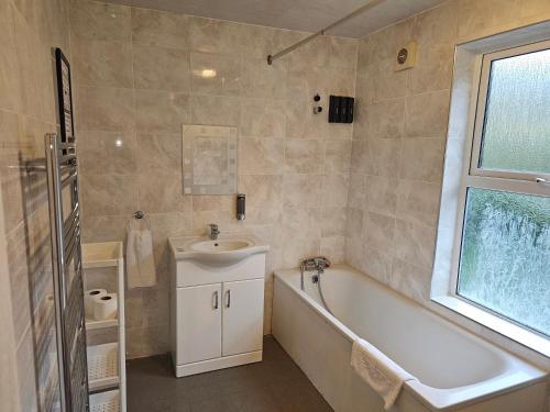 a bathroom with a sink and a bath tub and a sink at SAV Apartments - Russell, Luton (4 Bed House) in Luton