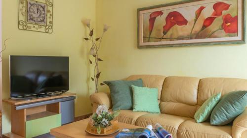 a living room with a couch and a tv at Welcomely - Gabbiani - Cala Gonone in Cala Gonone