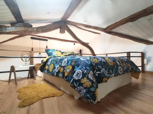 1 dormitorio con 1 cama en una habitación con suelo de madera en Gîte du Fassac en Saint-Julien-du-Puy