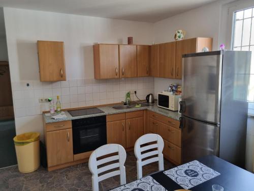 a kitchen with wooden cabinets and a stainless steel refrigerator at FEWO NEUBEEREN in Großbeeren