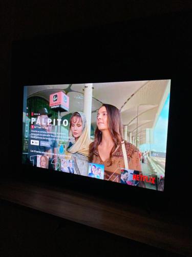 un écran de télévision avec une photo de deux femmes dans l'établissement Departamento Céntrico en Eldorado, à Eldorado