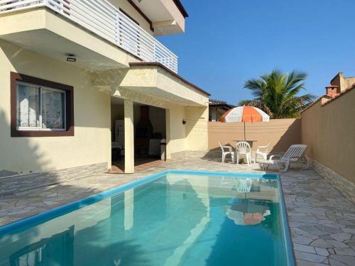 een zwembad voor een huis bij Beachouse Marissol Morada da Praia in Bertioga