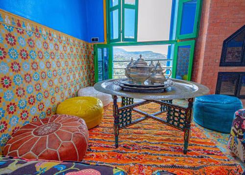 sala de estar con mesa y ventana en Amazing view and unique design in historic medina en Xauen