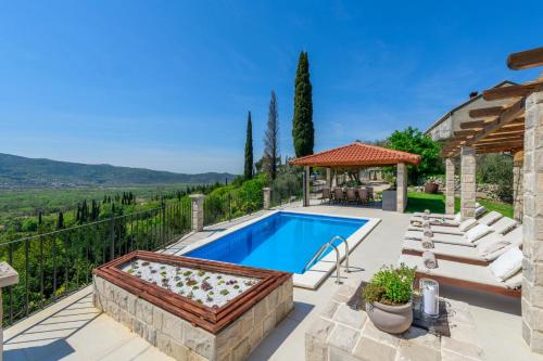 an outdoor swimming pool with a gazebo and a villa at Villa Velaga in Gruda