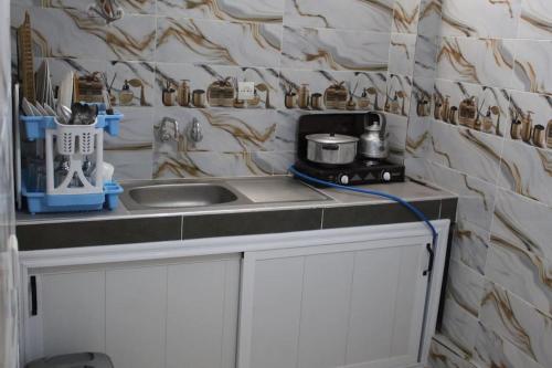 um balcão de cozinha com um lavatório e um fogão em Titrit House awrir em Aourir