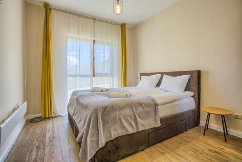 a bedroom with a large bed with a window at Cozy 2BD Apartment in Bansko in Bansko