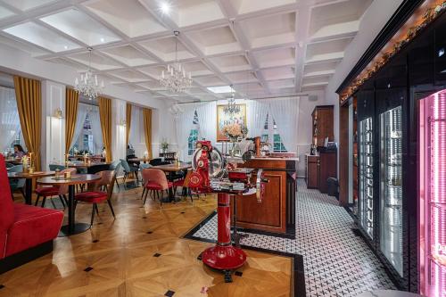 a living room with tables and chairs and a red table at Małopolanka & Spa in Krynica Zdrój