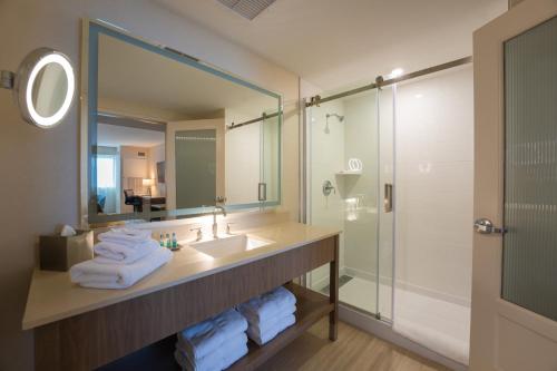 ein Bad mit einem Waschbecken, einem Spiegel und einer Dusche in der Unterkunft Mohegan Pennsylvania - Adults Only in Wilkes-Barre