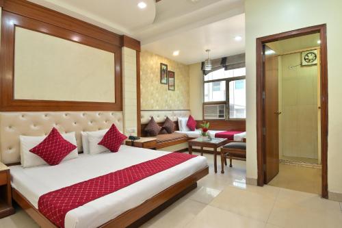 ein Schlafzimmer mit einem Bett und ein Wohnzimmer in der Unterkunft The Aster Karol Bagh Homely Atmosphere in Neu-Delhi