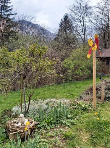 a garden with a windmill in the grass at InGreen house in Bohinjska Bela