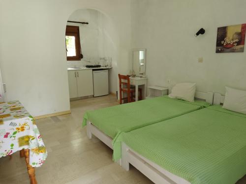 a bedroom with two twin beds and a kitchen at "Patra's" Apartments Patra in Poseidónion