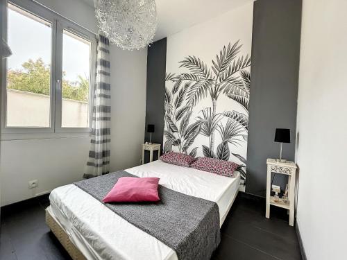 a bedroom with a bed with a plant mural on the wall at Les oiseaux du paradis in Sausset-les-Pins