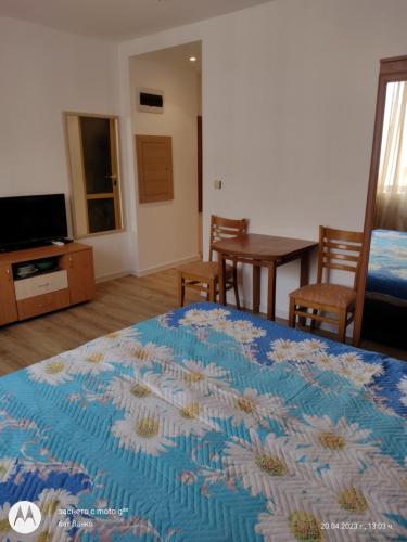 a bedroom with a bed and a dining room with a table at Аз и Ти in Sunny Beach