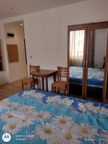 a bedroom with a bed and a table and chairs at Аз и Ти in Sunny Beach