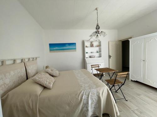 a bedroom with a bed and a table in it at CASE DEL MAR nel centro storico in Santa Teresa Gallura