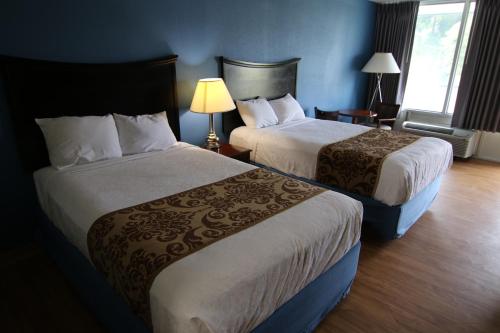 een hotelkamer met 2 bedden en een raam bij 121 Motel Battleboro in Battleboro