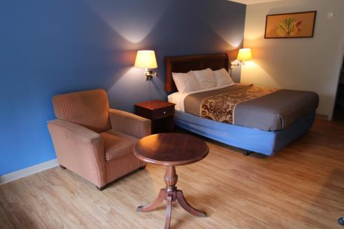Battleboro的住宿－121 Motel Battleboro，配有一张床和一把椅子的酒店客房