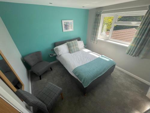 a bedroom with a bed and a chair and a window at Pen Mar Guest House B&B in Tenby