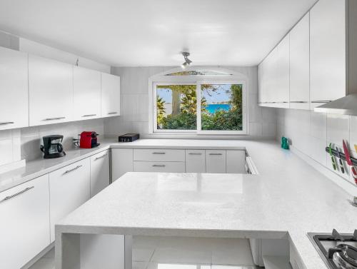 a white kitchen with a white counter top and a window at Puerto Velero Primera Línea Primer Piso al lado de la Playa! 8pax in Puerto Velero