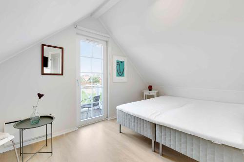 Un dormitorio blanco con una cama grande y una ventana en Charming Architect-designed Terraced House With Sea View, en Bro