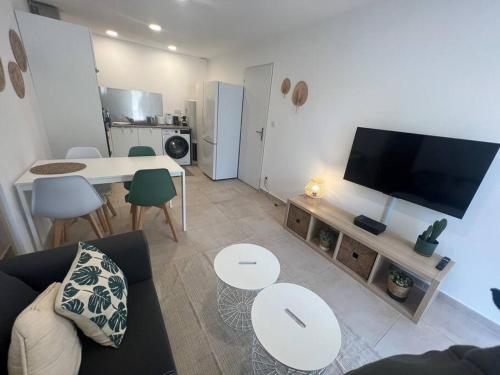 Il comprend un salon doté d'un canapé et d'une table avec une télévision. dans l'établissement La Glycine - Parking gratuit - AC CLIM - Cour privé -, à Villeneuve-lès-Avignon