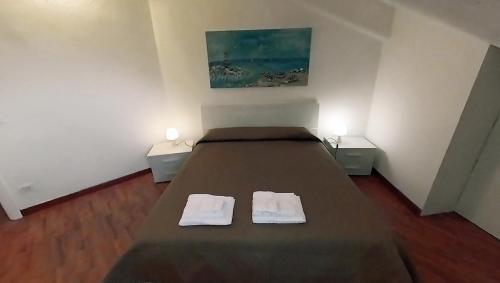 ein Schlafzimmer mit einem Bett mit zwei Handtüchern darauf in der Unterkunft VIOLA - A Due Passi Dal Mare in Savona