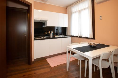 a kitchen with a white table and white chairs at Residence La Fenice in Padova