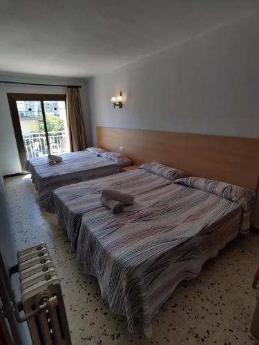 two beds in a room with a window at Raco d'en Pepe in Calella
