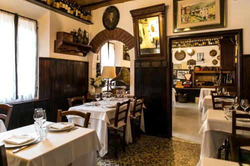 un restaurante con mesas y sillas blancas en una habitación en Antica Osteria del Mirasole, en San Giovanni in Persiceto