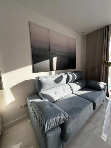 a living room with a blue couch with pillows at Apartment Malibu Sun & Relax in Adeje