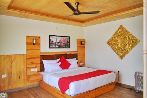 1 dormitorio con 1 cama con almohadas rojas y blancas en The Mountilla Resort, en Tehri-Garhwāl