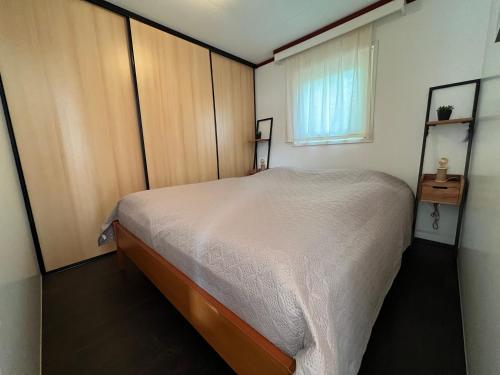 een kleine slaapkamer met een bed en een raam bij Chalet Havenzicht Eernewoude in Earnewâld