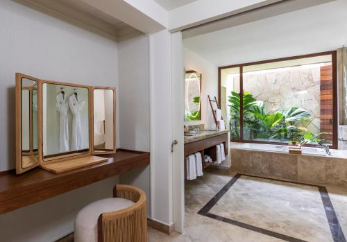 a bathroom with a tub and a sink and a window at Fairmont Mayakoba in Playa del Carmen