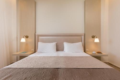 a bedroom with a large bed with two night stands at Niki Sunrise Apartments in Gastourion