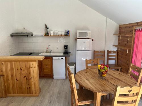 a kitchen with a wooden table and a kitchen with a table and chairs at Les Chalets de Montclar Azur et Neige in Montclar