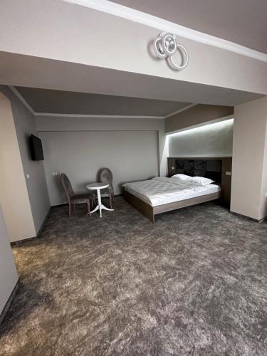 a bedroom with a bed and a table and a chair at Romula Imperial in Caracal