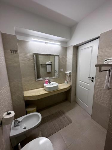 a bathroom with a sink and a toilet and a mirror at Romula Imperial in Caracal