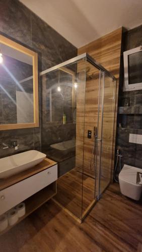 y baño con ducha acristalada y lavamanos. en Saranda Center (above promenade), en Sarandë