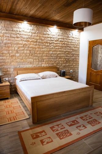 a bedroom with a bed and a brick wall at Eni entire guesthouse parking on site in Berat